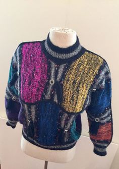 "This 1980s patchwork multi color knit sweater with tassels and concha style buttons is up to the minute style. 65% wool 30% acrylic  5% nylon Size S Measurements: bust=36\" waist=36\" @hem=32\" sleeve=20\" length=20\" shoulder=32\" Very good vintage condition. No holes, pulls or damage." Multicolor Wool Patchwork Sweater, Multicolor Wool Sweater With Patchwork, Fitted Vintage Multicolor Sweater, Fitted Multicolor Patchwork Sweater, Black Turtleneck Sweater, Mock Turtleneck Sweater, Oversized Turtleneck Sweater, Lace Party Dresses, Rayon Shirt