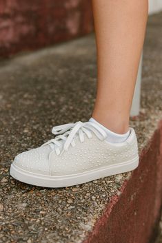 Elevate your outfit with our White Pearl Sneakers! These lace-up sneakers feature beaded pearls for a touch of sophistication. Not only stylish, they're also comfortable for all-day wear. Pair these versatile sneakers with so many different looks! runs true to size Spring Synthetic Sneakers With Rhinestones, Casual Rhinestone Sneakers For Spring, Casual Low-top Sneakers With Rhinestones, Elegant Lace-up Sneakers For Spring, Trendy Rhinestone Sneakers For Spring, Casual Sneakers With Rhinestones And Round Toe, Spring Sneakers With Rhinestones, Elegant Low-top Sneakers With Perforated Toe Box, Elegant Low-top Sneakers With Laces