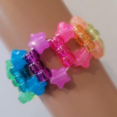 three bracelets that have different colored beads on each one wrist and are attached to someone's arm