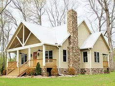 a house in the woods with a porch and stairs leading up to it's front door