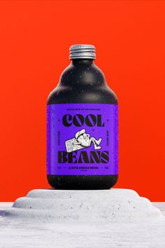 a purple bottle sitting on top of snow covered ground next to an orange wall and red background