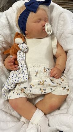 a baby is sleeping with a stuffed animal