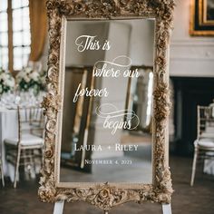 a mirror with a wedding sign on it sitting in front of a table and chairs