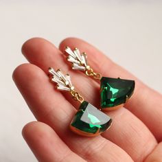 These great earrings are brass and feature a graduated art deco design. The tiny cubic zirconia jewels are cut into perfect rectangles. They remind us of classic Deco architecture, like the Chrysler building! The classically cut fan shaped stone is also glass in a beautiful, rich emerald green shade. The earrings measure 40mm (an inch and a half) in length and have gold plated ear wires. The emerald fan stone is designed to hang just below the earlobe. This piece of handmade jewellery comes pack Art Deco Jewelry 1920s, Art Deco Drop Earrings, Art Deco Emerald, Green Art Deco, Deco Architecture, Photo Locket Necklace, Oval Locket, Chrysler Building, Earrings Art