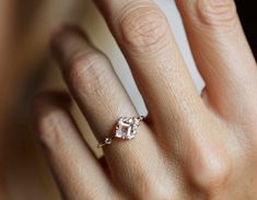 a woman's hand with a diamond ring on it