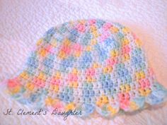 a crocheted baby hat is laying on a blanket with the words, it clement's daughter