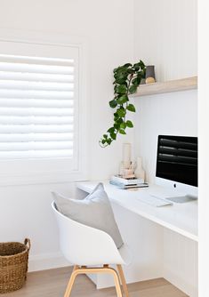 a white chair sitting in front of a computer monitor on top of a wooden desk