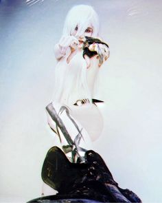 a woman with white hair holding a pair of scissors in her right hand and wearing high heels