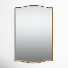 a mirror that is on the wall in front of a white wall with a gold frame