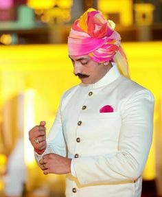 a man in a turban is looking at his watch