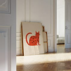 an orange cat sitting on top of a wooden floor next to a white wall and door