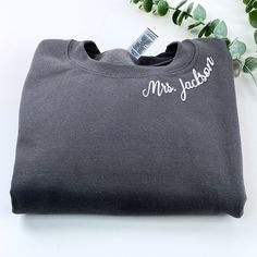 a gray t - shirt with the word mr jackson printed on it and a green plant in the background