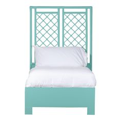 a bed with a white pillow on top of it and a blue headboard above it