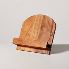 a wooden cutting board with a knife holder on it's side, sitting on a white surface