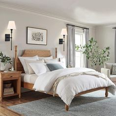 a bedroom with white bedding and wooden furniture