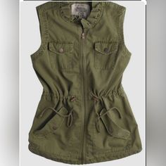 Route 66 Outdoor Cargo Vest Nwt Size M 100% Cotton Fabulous 90’s Safari Vest In A Very Rich Olive Green. Stand Up Ruffle Collar Detail Sets This One Apart. Zip Closure. Upper Front Snap Flap Pockets. Lower Slash Pockets With Snap Flap Detail. Drawstring Waist. Bronze Hardware. Hi/Lo Hem With Split Rivet Detail.#Vintage #Layering #Safari #Utility #Eclectic #Unique #Adventure #Travel Casual Workwear Vest With Cargo Pockets, Cotton Military Tops For Outdoor Activities, Khaki Cargo Pocket Top For Spring, Khaki Tops For Outdoor Activities In Fall, Khaki Tops For Fall Outdoor Activities, Military Tops With Pockets For Outdoor Activities, Green Casual Vest With Pockets, Casual Green Vest With Pockets, Spring Military Vest With Pockets