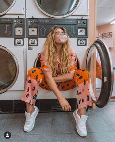 a woman sitting on top of a washing machine