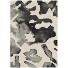 a rug with black and white paint splattered on it's surface, in the shape of an animal print