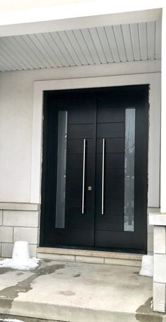 two black double doors in front of a house