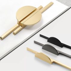 three different types of handles on a white surface, one with gold and the other black