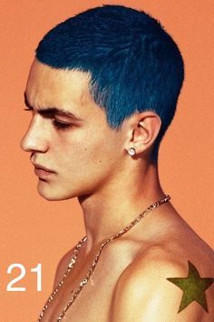 a young man with blue hair and piercings on his ear, wearing a necklace