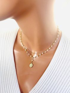 "This 14k gold-filled Miraculous Mary multi strand pendant necklace with freshwater pearls approximately 3-3.5mm.  This necklace features a top strand that is 14k gold filled shiny cable chain above a lariat style Y necklace in beautiful pearls.  A double side 14k gold filled miraculous medallion hangs from drop.  Total drop length is 1.25\". Spring clasp on back connects both layers.  Mary pendant measures 17x11mmModel is wearing a 15\" length in photos. That is the measurement of the top strand.  Choose your desired top strand length.  Comes in a gift box ready to present! If you desire something other than pearls send me a message to converse." Gold Multi-strand Pearl Necklaces, Pearl Drop Layered Necklace Gift, White Pearl Pendant Layered Necklace As Gift, White Layered Pearl Pendant Necklace As A Gift, White Layered Necklace With Pearl Pendant As Gift, Gold Multi-strand Pearl Charm Necklace, Gold Double Strand Pearl Necklaces, Pearl Drop Multi-strand Jewelry Gift, Gold Multi-strand Necklace With Pearl Charm