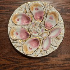 a white and pink plate on top of a wooden table next to a brown wall