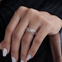 a woman's hand with white manicured nails and a ring on her finger