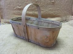 an old wooden basket sitting on top of a burlied cloth covered tablecloth