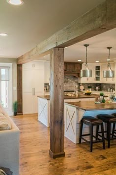 a living room filled with furniture next to a kitchen and an open concept floor plan