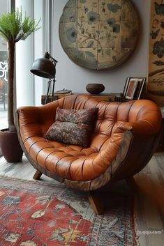 a brown leather chair sitting on top of a wooden floor next to a lamp and rug