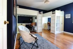 an empty room with blue walls and white bookcases on the wall, while a folding chair sits in front of it