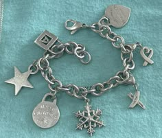 Rare Authentic Tiffany & Co Heavy Sterling Silver Multi Charm Link Bracelet with 7 Charms. It comes with the original Tiffany packaging. There are 7 Charms total. Includes the following charms. Removable Paloma Picasso Graffiti X. Removable Paloma Picasso Loving Heart. Please Return to Tiffany Heart. Large Snowflake. Merry Christmas. Initial A Lock. Star. Bracelet is in Good Pre Owned Condition, weighs 64.70 grams. Has a Large Lobster Lock. Free Shipping. All jewelry will be sanitized and securely wrapped and packaged for your safety & piece of mind. Please ask any questions before bidding. Thank you Shipped with USPS First Class Excellent condition for its age. ANY QUESTIONS? PLEASE ASK BEFORE BIDDING. .FREE SHIPPING.. THANKS FOR LOOKING !! Year 2000 Fashion, Tiffany Jewelry Bracelet, Tiffany Charm Bracelets, Tiffany Packaging, Tiffany Charm Bracelet, Tiffany Bracelet, Piece Of Mind, Initial A, Return To Tiffany