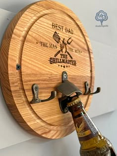 a beer bottle is hanging on the wall next to a wooden barrel holder with an opener