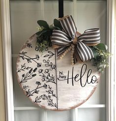 a wooden sign that says hi hey hello hanging on the front door with a bow