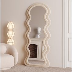 a large white mirror sitting on top of a floor next to a chair and lamp