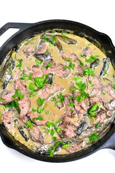 a skillet filled with meat and mushrooms