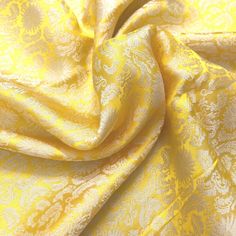 a yellow and white fabric with an intricate pattern