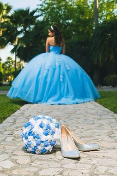 a ball and shoes sitting on the ground in front of a woman wearing a blue dress