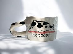 a coffee mug with a cow painted on it