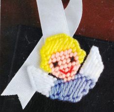 an embroidered angel ornament on a white ribbon