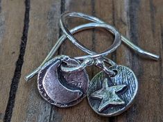 "These sweet little sterling silver, Artisan-crafted charms feature a moon and star on one side and the words \"dream\" and \"faith\" are written on the back. The charms are hung from sterling silver fishhook ear wire. The total length is approximately 22mm ( about 3/4\"), from the top of the ear wire to the bottom of the charm. If you have any questions, please Convo me. See more finished jewelry here - https://www.etsy.com/shop/StaggsLaneSupplies?ref=seller-platform-mcnav&section_id=35982098" Sterling Silver Spiritual Earrings With Moon Charm, Spiritual Sterling Silver Earrings With Moon Charm, Sterling Silver Moon Charm Earrings As Gift, Symbolic Moon Charm Earrings For Gift, Symbolic Moon Charm Earrings Gift, Silver Moon Charm Earrings, Silver Symbolic Moon Charm Earrings, Symbolic Silver Moon Charm Earrings, Symbolic Silver Earrings With Moon Charm