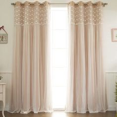 the curtains in this room are made of sheer fabric and have flower embroidered on them