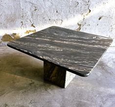 a marbled table sitting in front of a white wall