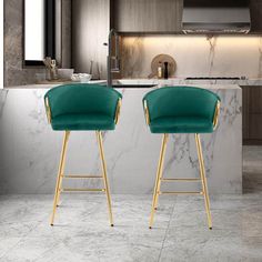 two green velvet bar stools in front of a marble kitchen island with gold legs