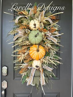 a front door with a wreath and pumpkins on it