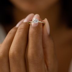 a woman's hand holding a diamond ring