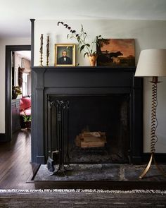 a living room with a fireplace and pictures on the mantle