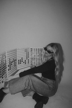 a woman sitting on the floor with her legs crossed and eyes closed, next to several domino boards