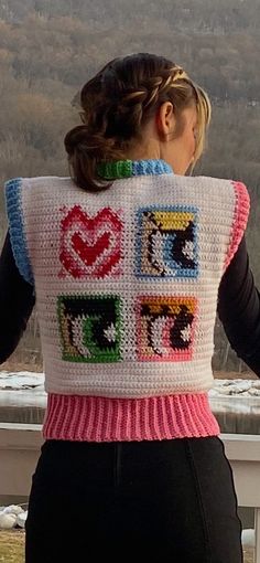 the back of a woman's sweater that has been crocheted with squares and hearts